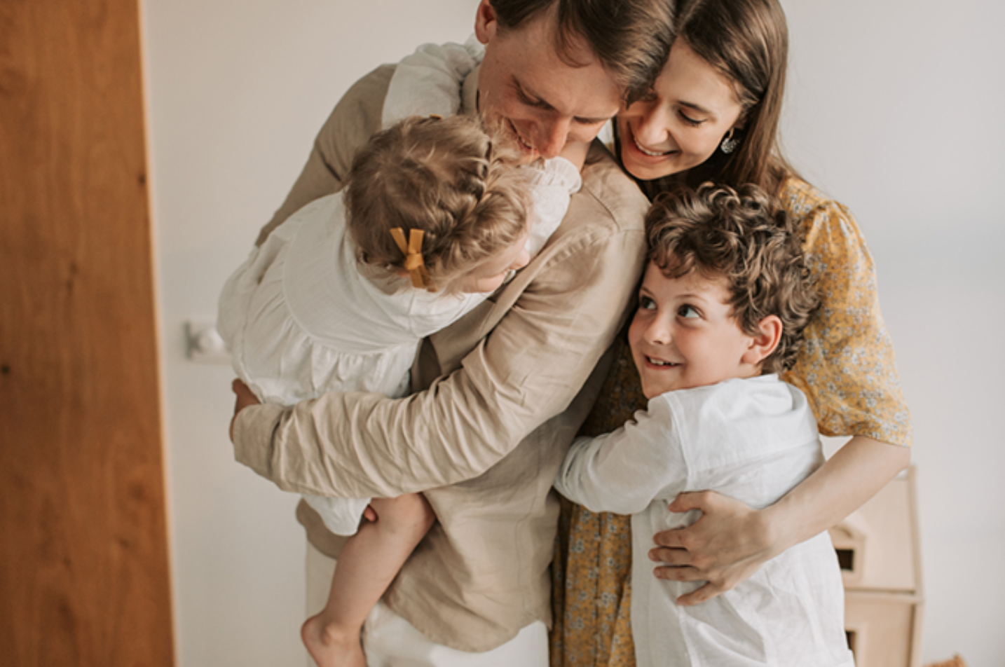 Parents embracing their two young children at home